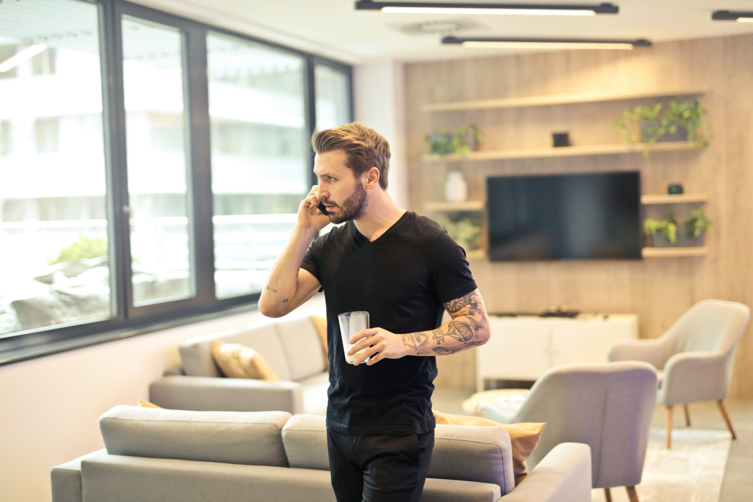 A businessman holding a cellphone and a cup, engaging in conversation while conducting business, representing stewardship in adversity by balancing daily tasks with integrity and faith.