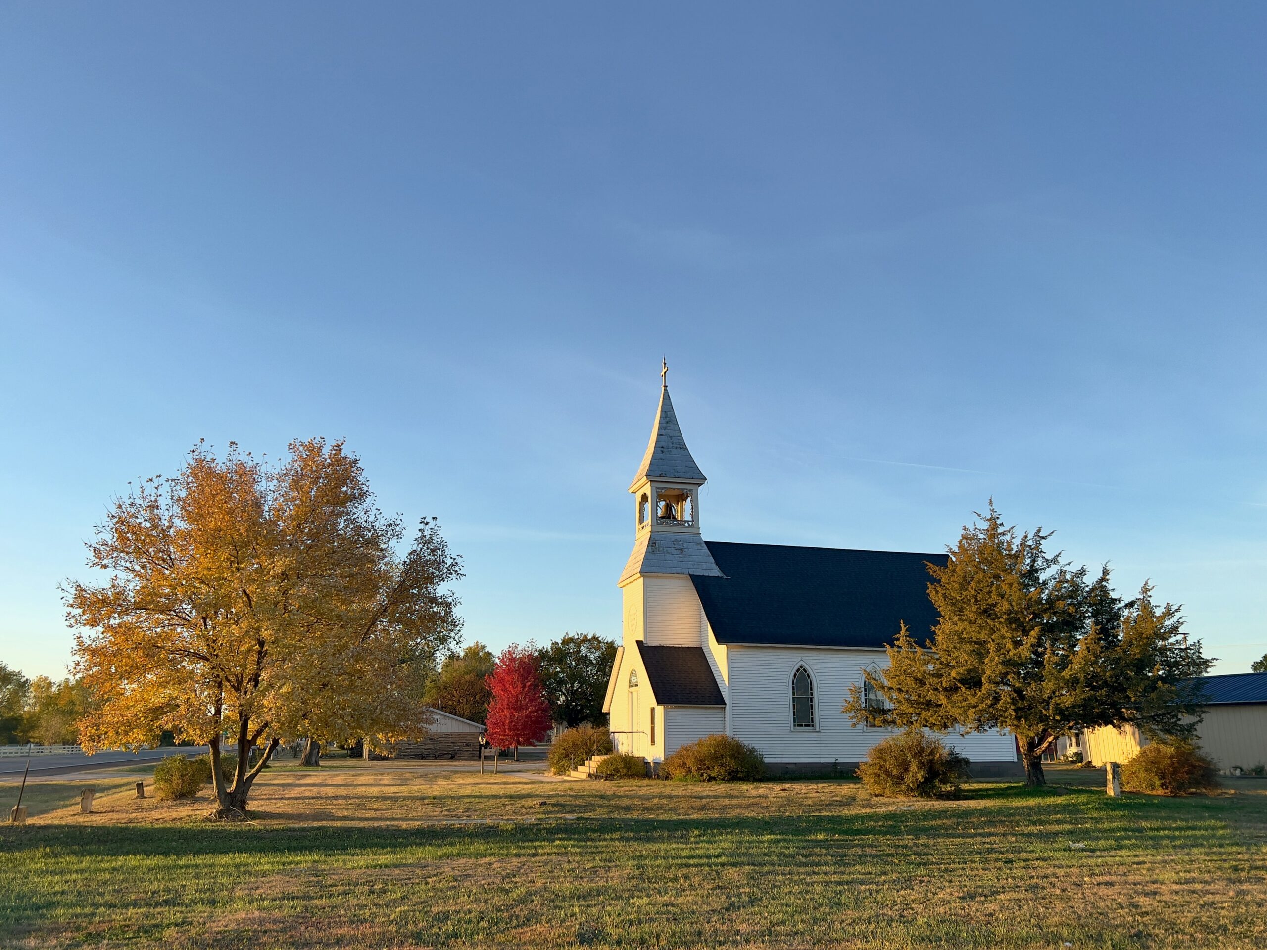 a white church with a black roof and steeple kansas